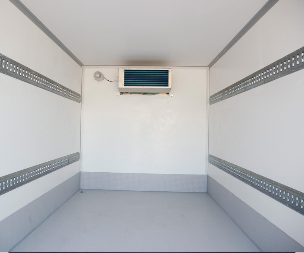 Interior of an empty Next Can refrigerated trailer with shelving and a cooling unit, available for efficient refrigerated storage in Marion.