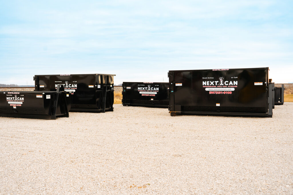 Array of large black Next Can dumpsters lined up on a gravel lot, signifying robust options for dumpster rental in Marion, Ohio.