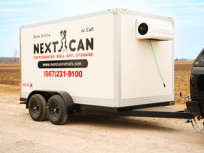 Close-up of refrigerated rental trailer hitched to a black pickup truck.