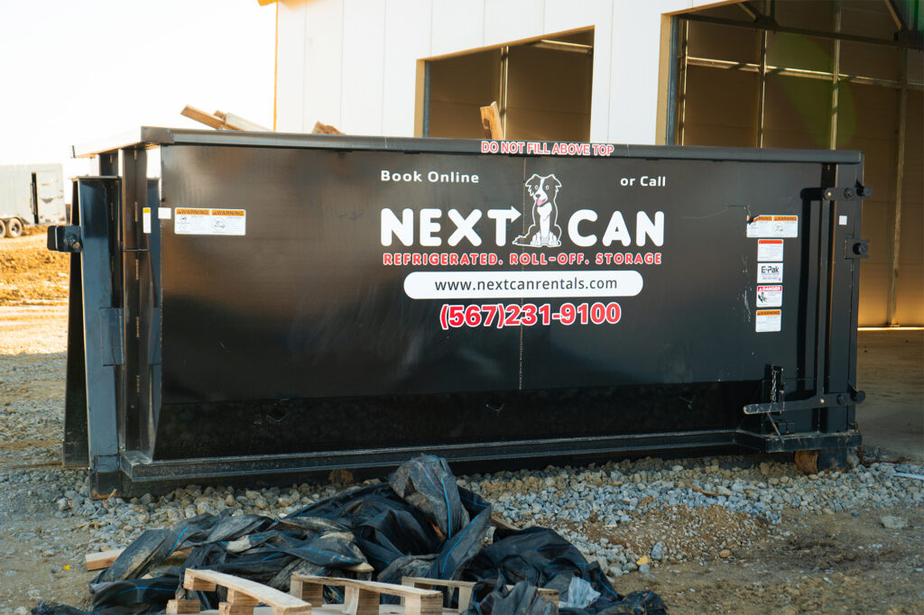 Next Can dumpster at a construction site with debris ready for cleanup