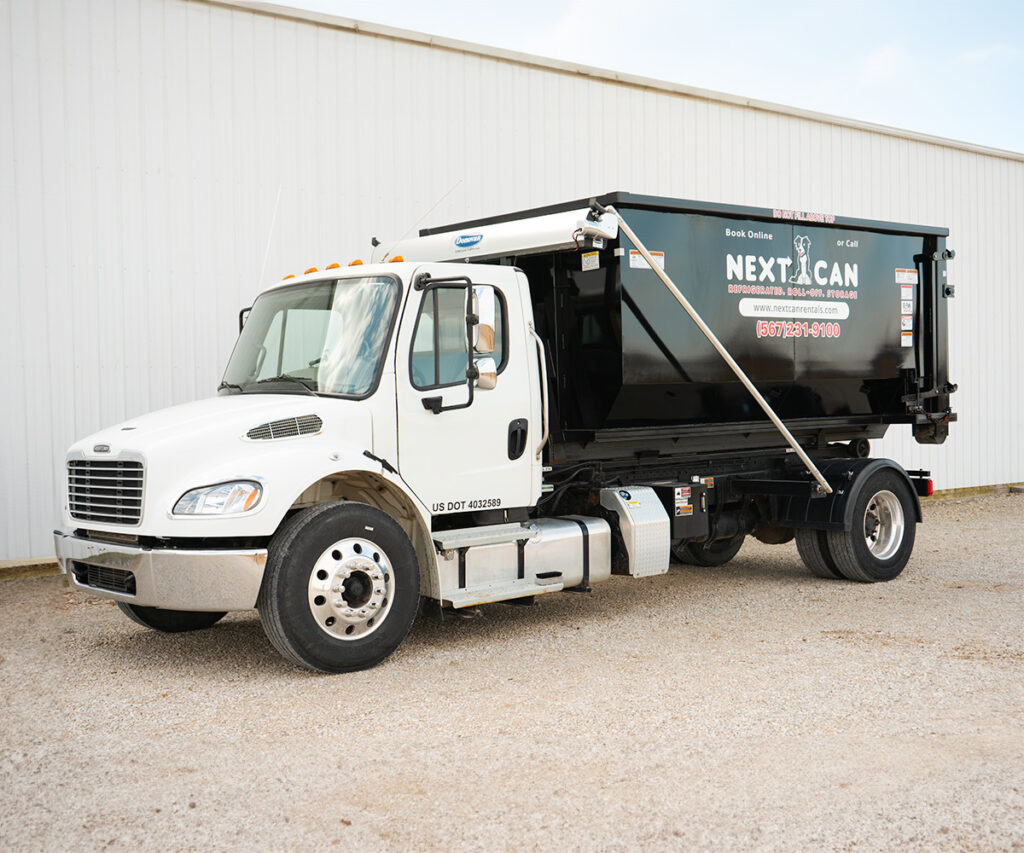 Frontal view of a white Next Can roll-off dumpster truck 