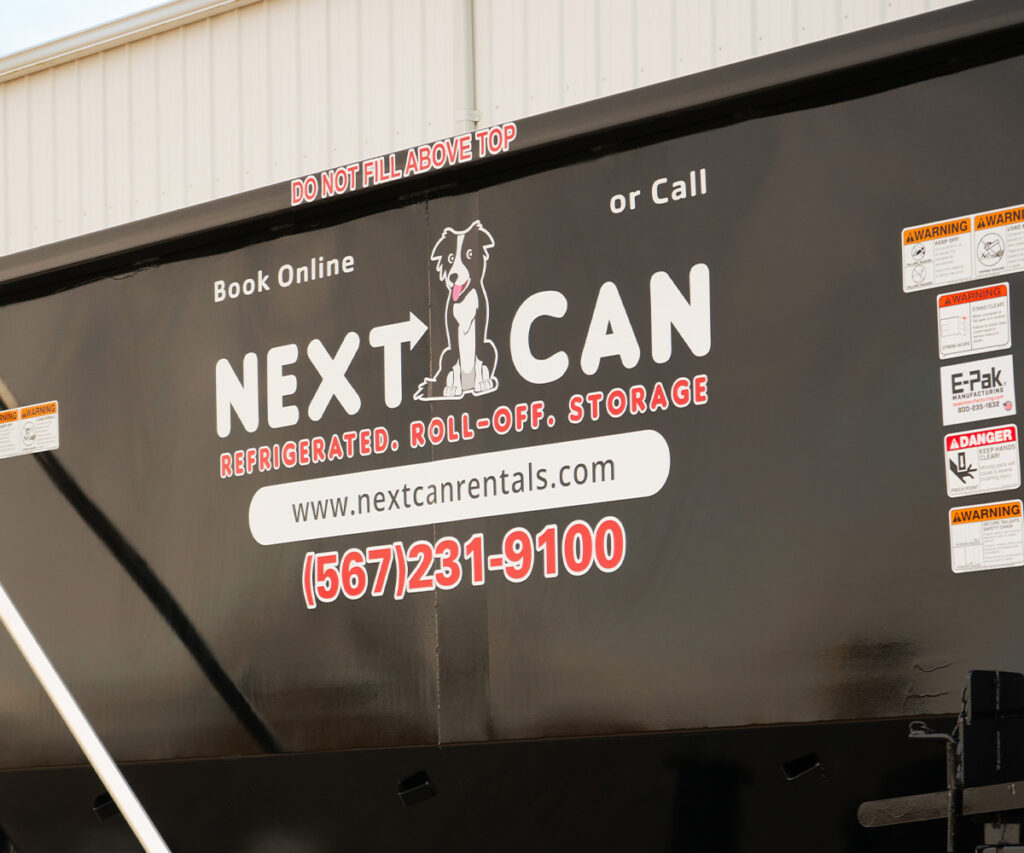 Close-up view of the side of a black Next Can dumpster displaying the company logo and contact information.