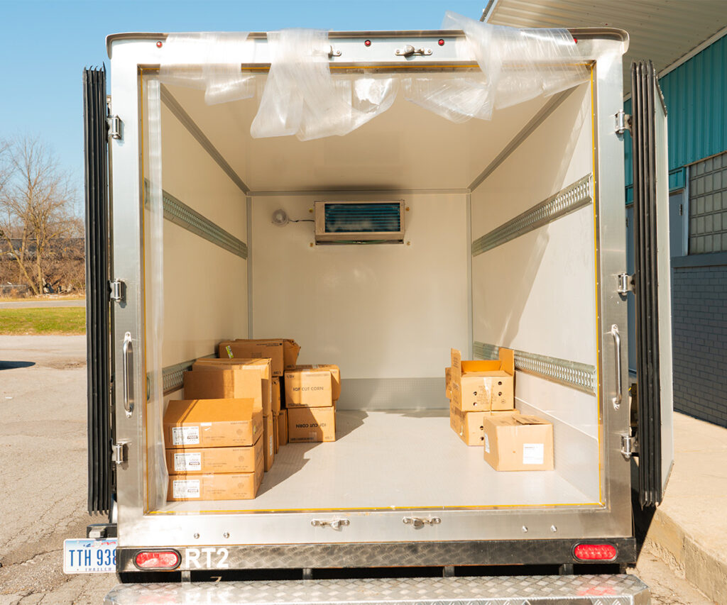 Open refrigerated trailer with boxes inside.