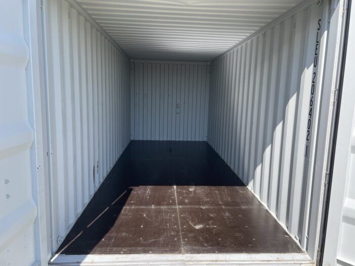 Interior of an empty portable storage container with metal walls and wood flooring.