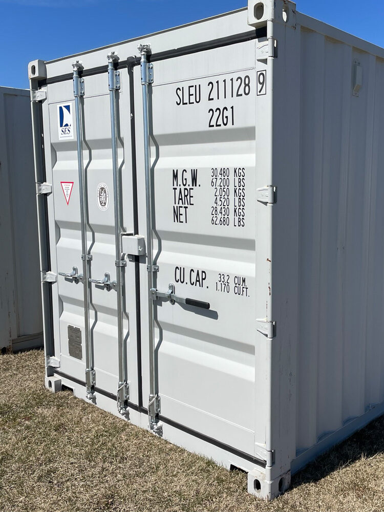 White storage container on grass under blue sky.